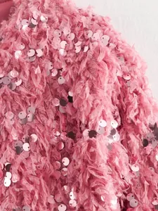 Nahaufnahme der rosa Zottelstoff-Textur mit runden Pailletten auf der Langarmjacke