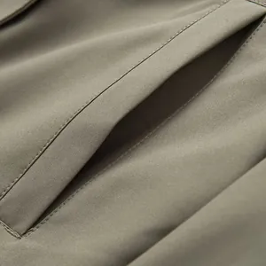Dettaglio della cucitura della tasca e della trama del tessuto di un parka verde