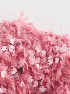 Makroansicht der pinkfarbenen Pailletten- und Federfransenstruktur eines Damenjacken-Details