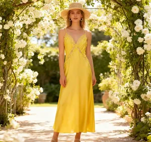 Detail of elegant yellow satin midi dress with delicate lace trim and V-neckline