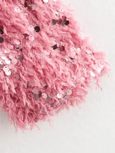 Detailansicht einer rosa Paillettenjacke mit Federfransen und Metallelementen.