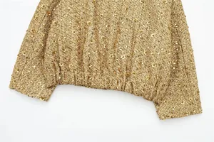 Close-up detail of golden sequined jacket showing hem texture and paillettes