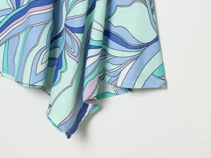 Gros plan détaillé montrant le motif floral abstrait bleu et cyan sur l'ourlet d'une robe