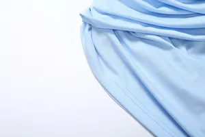 Detail showing the soft light blue fabric texture and precise stitching on the dress hem