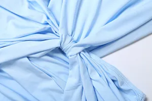 Detailed macro view showing the elegant twist knot and soft ruching on a light blue dress