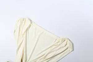 Detailed macro view showing pleated neckline texture on cream sleeveless dress.