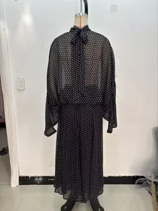 Rückansicht der schwarzen Punktebluse mit Halsschleife und passendem Midirock.