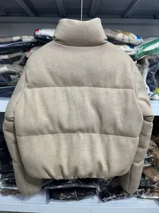 Achteraanzicht van een beige gebreide pufferjas met opstaande kraag en gewatteerd