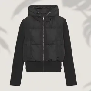 Close-up of women's black hybrid hooded padded jacket with slim fit quilted design