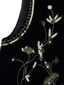 Macro detail van zwart fluwelen vest met gouden bloemenborduursel en pailletten.