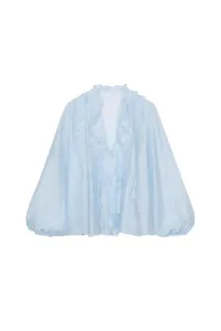 Detail view of a light blue V-neck blouse with elegant tiered ruffle decorations.