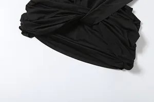 Close-up detail of the elegant knotted waist and ruched fabric texture on a black sexy dress