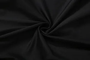 Close-up detail of the soft texture and elegant pleats of the solid black dress fabric.