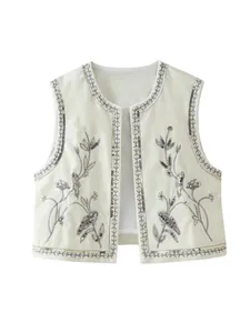 Chique witte mouwloze damesvest met delicaat zilveren bloemenborduurwerk en pailletten details