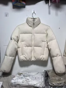 Detailweergave van een crèmekleurige gebreide pufferjas met opstaande kraag voor de winter