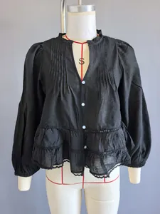Camicetta nera stile francese con pizzo, volant e maniche lunghe a sbuffo da donna.