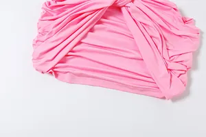 Detailed close-up view of the elegant ruched and pleated fabric texture on a pink dress