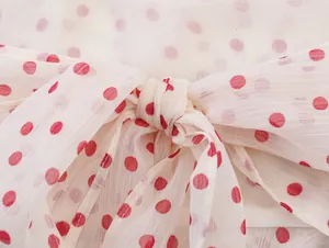 Detailansicht eines süßen Polka-Dot-Halter-Tops aus Georgette mit dekorativer Schleife.
