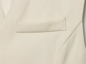 Detailed close-up showing the flap pocket and fine stitching on a beige women's suit vest