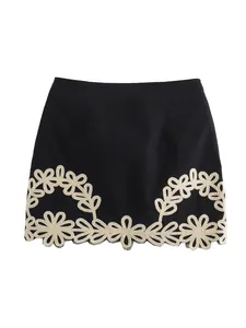 Elegante minigonna nera con squisito ricamo floreale beige lungo l'orlo inferiore