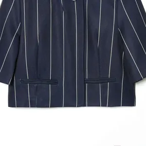 Detailed view of a navy blue pinstripe blazer featuring high-quality fabric and pockets