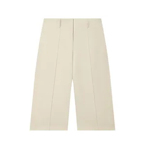 Detailed view of cream wide-leg shorts with hidden button closure and front pleats