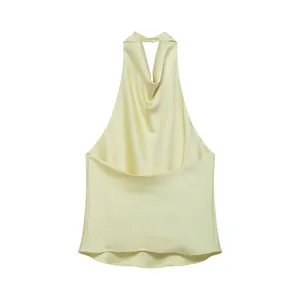 Close-up of pale yellow satin halter top featuring a backless design and cowl neck detail.