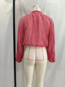 Back view of pink pleated long-sleeved crop top on mannequin showing fabric texture