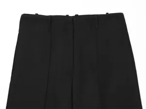 Close-up detail of high-waist black trousers with hidden button closure and belt loops.