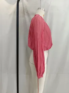 Side view showing the pleated texture of the pink long sleeve cropped top detail.