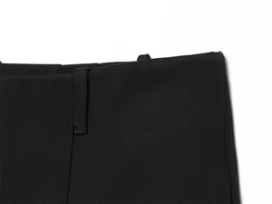 Close-up of black shorts waistband showing belt loop and fine stitching details.