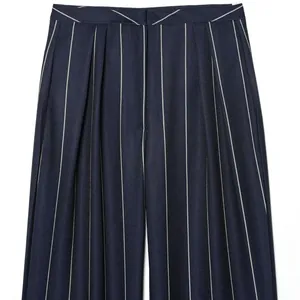 Close-up detail of navy blue pinstripe trousers with elegant high-waisted pleats