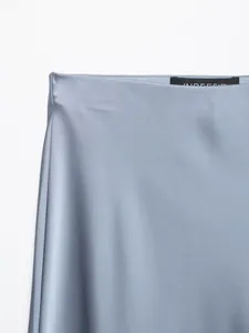 Detalle de primer plano de cintura de falda de satén azul con suave textura de seda