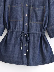 Detailed view of denim jacket with adjustable drawstring waist and double chest pockets