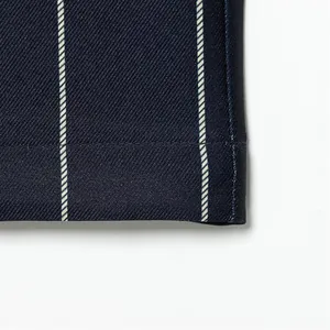 Macro shot of navy blue pinstripe fabric texture and hem stitching detail