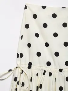 Detalle de tela blanca con lunares negros y un nudo de lazo en el lateral de ropa
