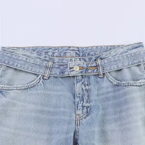 Detailed view of women's light blue denim jeans showing waistband and metal button