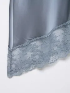 Primer plano detallado del elegante borde de encaje floral en falda de raso azul