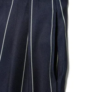 Close-up of navy blue pinstripe trousers showing pocket detail and fabric texture.