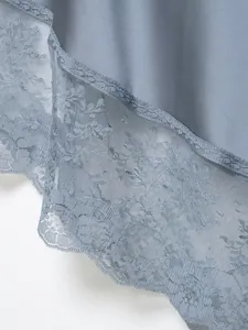 Detalle del dobladillo de falda de satén azul con ribete de encaje floral fino.