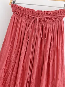 Close-up of a dusty rose pleated midi skirt featuring a ruffled paperbag waist and front tie