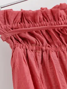 Detail shot of the elasticated smocked waist on a coral red skirt showing fabric texture