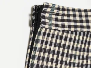 Macro close-up detail of a vintage plaid checkered skirt featuring a black invisible zipper