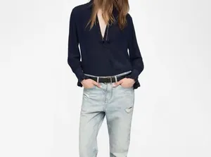 Detailed macro view of navy blue satin island silk blouse with elegant ruffled cuff sleeves