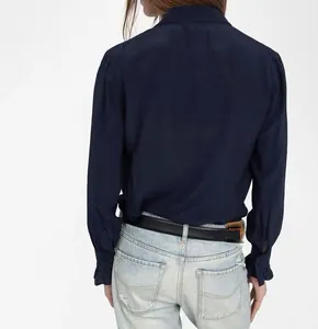 Macro detail view of navy blue satin shirt featuring ruffled cuffs and soft fabric texture