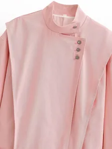 Detailed macro of pink stand-collar jacket featuring asymmetrical metallic buttons