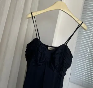 Λεπτομερές κοντινό πλάνο μπλε σκούρου πλισέ μπούστου σε μάξι φόρεμα με λεπτές τιράντες