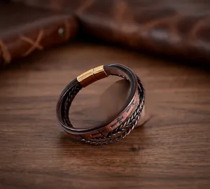 Détail rapproché d'un bracelet vintage en cuir tressé à la main avec fermoir magnétique doré