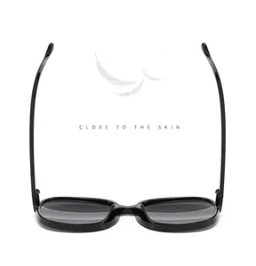 Top view of black vintage round sunglasses with lightweight feather background
