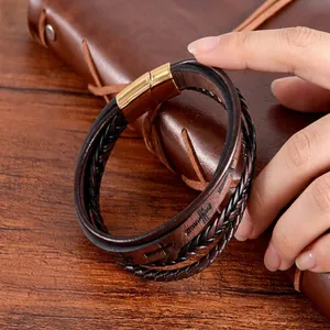 Détail macro d'un bracelet en cuir tressé vintage avec fermoir magnétique gravé d'une croix